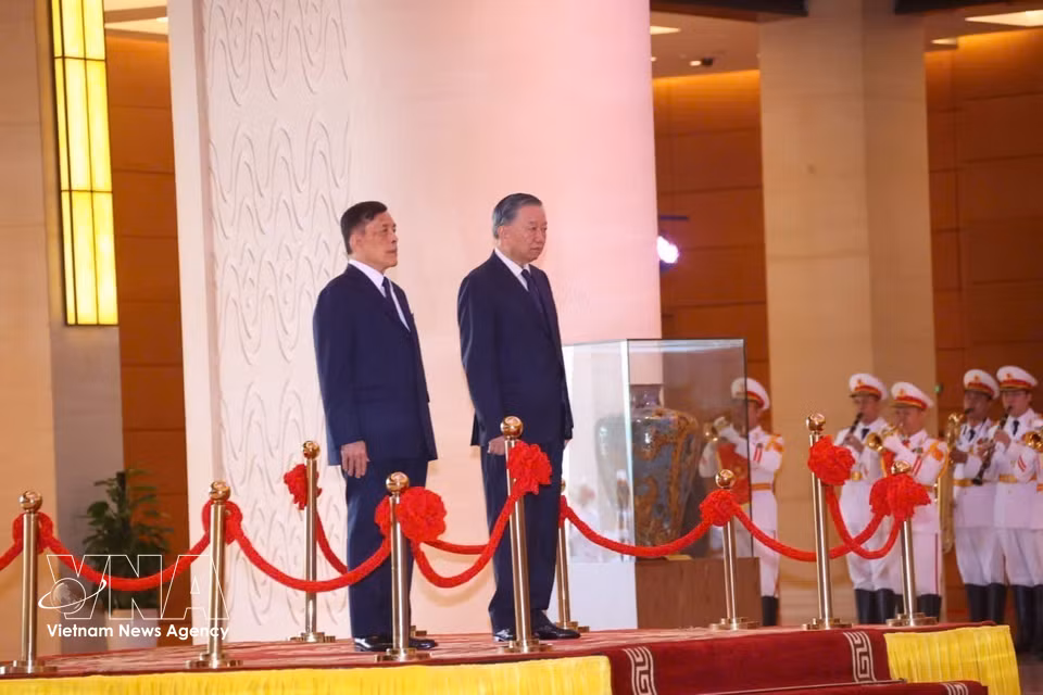 越共中央总书记、国家主席苏林与泰国国王玛哈·哇集拉隆功在检阅台上举行升旗仪式。图自越通社