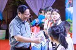 范明政总理向学生们赠送礼物。图自越通社