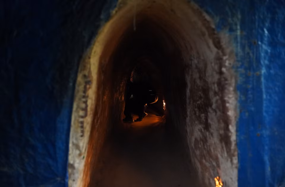 由于地道空间狭小且昏暗，参观者必须贴近地面弯腰前行，才能在其中移动。图自 越通社