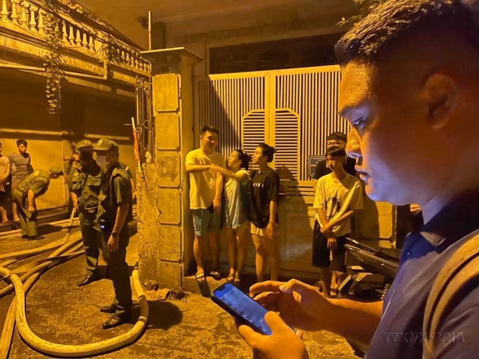 越通社记者在河内市青春郡姜下街一公寓楼发生特大火灾现场进行报道。图自越通社