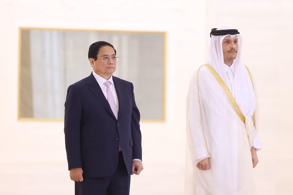 越南政府总理范明政和卡塔尔国首相穆罕默德·本·阿卜杜拉赫曼·阿勒萨尼登上检阅台，军乐团奏两国国歌。图自越通社