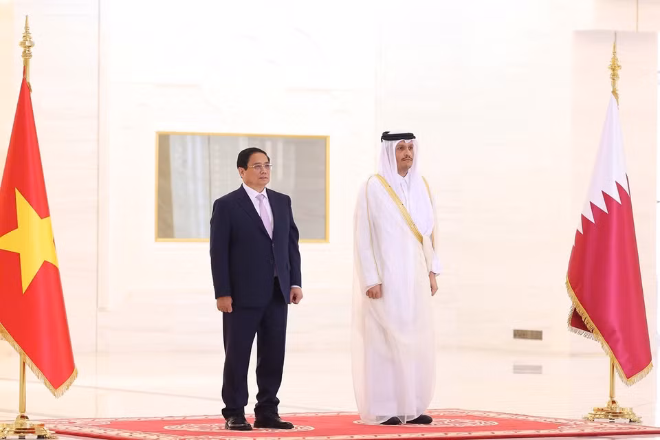 越南政府总理范明政和卡塔尔国首相穆罕默德·本·阿卜杜拉赫曼·阿勒萨尼登上检阅台，军乐团奏两国国歌。图自越通社