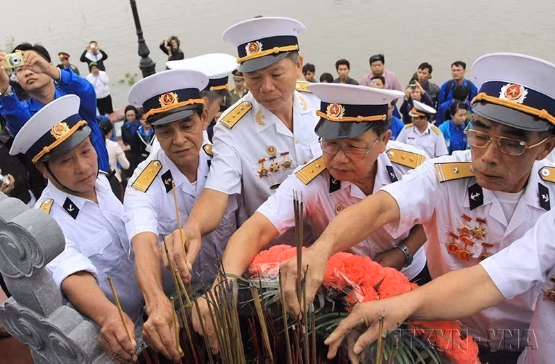 “无号船”老兵们在海防市涂山的K15无号船码头纪念碑点燃香烛，缅怀为祖国牺牲的战友们。图自：越通社发