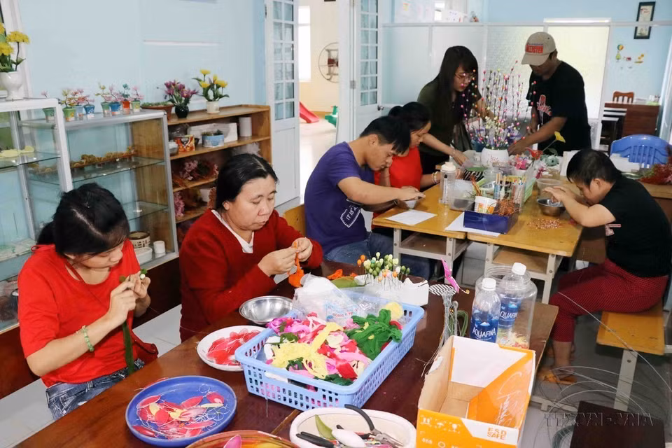 橙毒剂受害者在岘港市橙毒剂/迪奥辛受害者协会第三号中心获得雪纺花制作职业培训。图自越通社