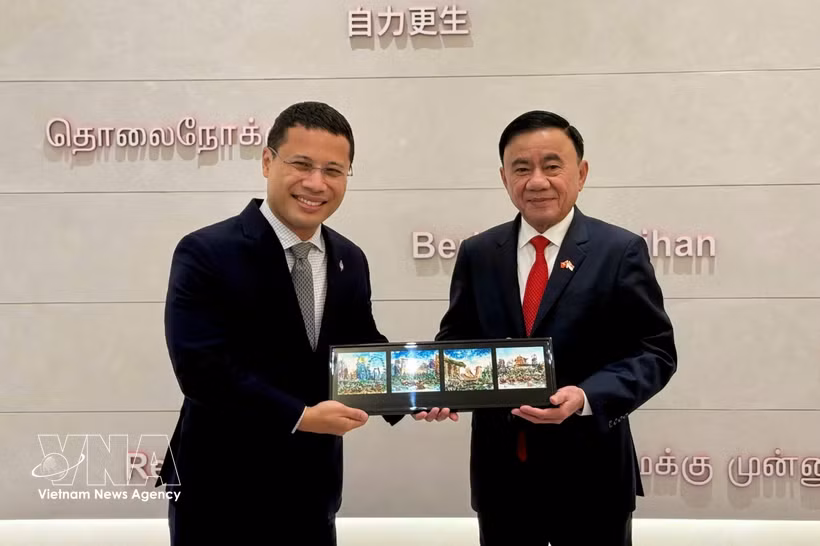 越共中央政治局委员、中央书记处常务书记陈锦秀与新加坡人民行动党主席、政府教育部长李智陞互送纪念品。图自越通社