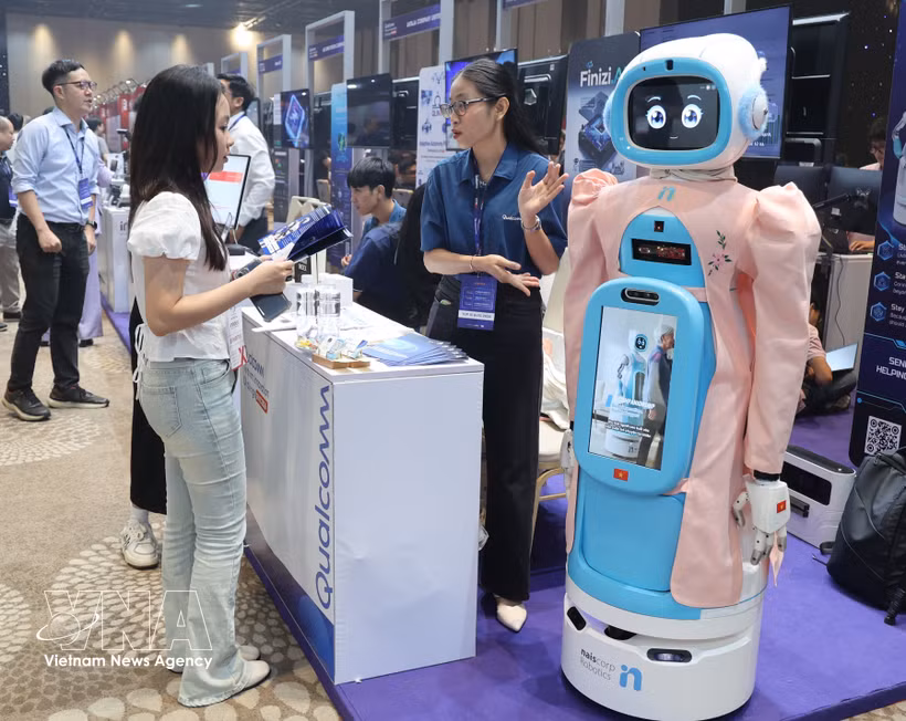 参观者在Qualcomm展台了解老年人护理机器人模型。图自越通社