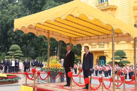 两位领导登上检阅台，军乐队奏起两国国歌。图自越通社