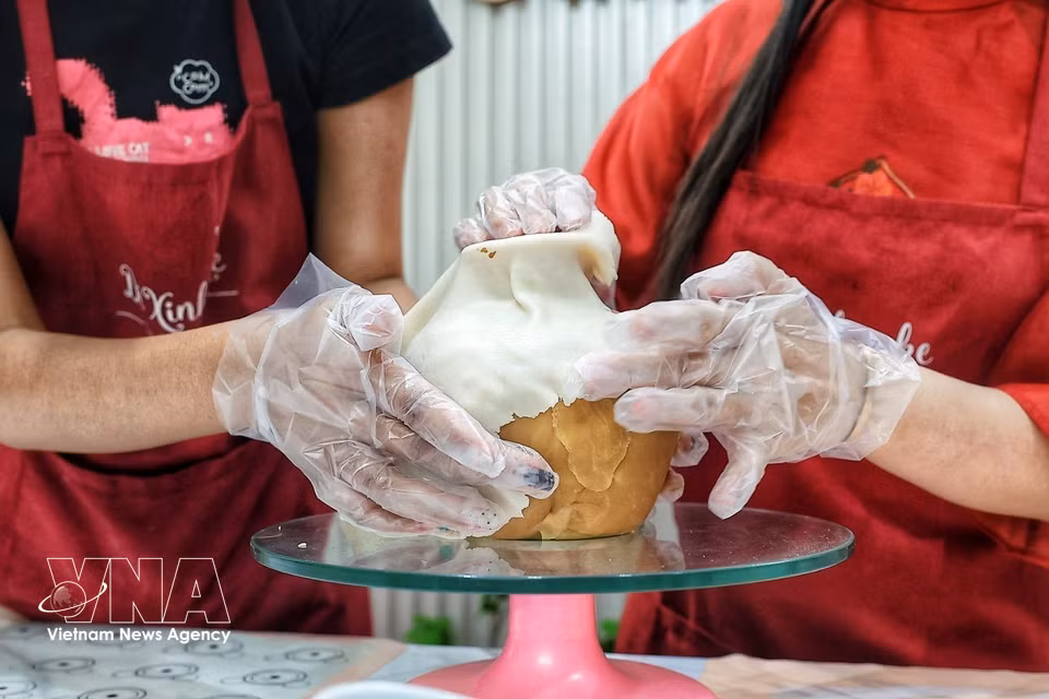 花瓶逐步塑形，用于插放以月饼制作技艺塑造的花枝。图自越通社
