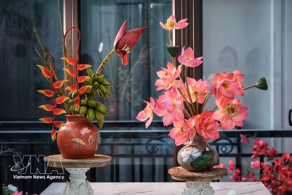 由月饼原料和捏面人原料塑造而成的莲花、香蕉花等花瓶，呈现出不同的色彩和造型，让人很难看出这些作品竟是可以食用的食品。图自越通社