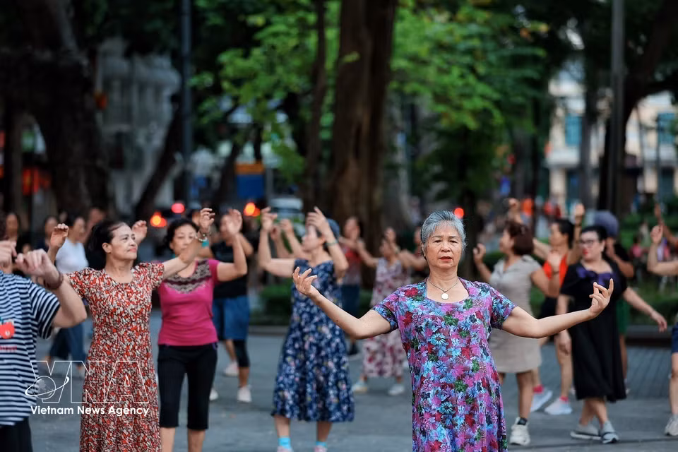 一群老年妇女养生保健操，保持身体柔韧性和乐观心态。图自越通社