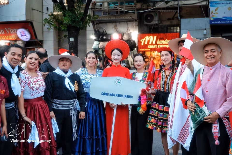 2026年10月3日下午，在参加“异彩五洲”街头艺术节之前，身着传统服饰的秘鲁代表团成员在还剑湖区域合影留念。图自越通社