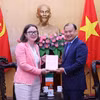 胡志明国家政治学院常务副院长黎海平向爱尔兰驻越南大使狄德拉·尼·法林赠送纪念品。图自越通社