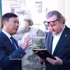 河内市人民委员会副主席杜英俊向布拉格市副市长彼得·赫拉瓦切克赠送纪念品。图自越通社
