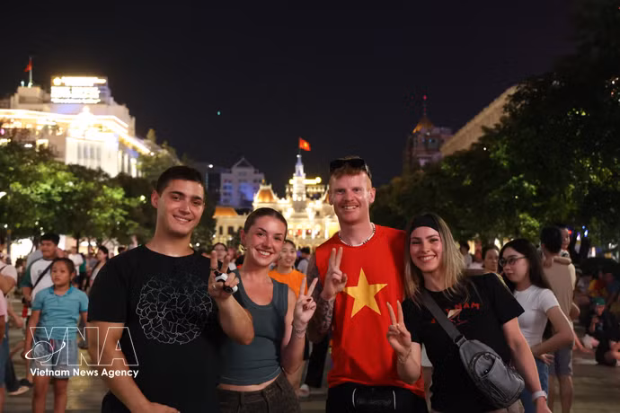 外国游客融入胡志明市市中心国庆夜晚的热闹氛围。图自越通社